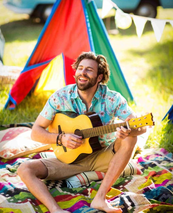 man-playing-guitar-at-campsite-CNVCZZA-1.jpg